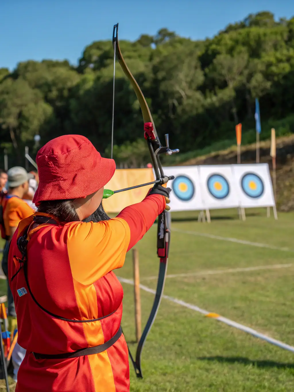 Archers competing in a local archery tournament, showcasing their precision and focus while aiming at targets, with spectators watching in the background.